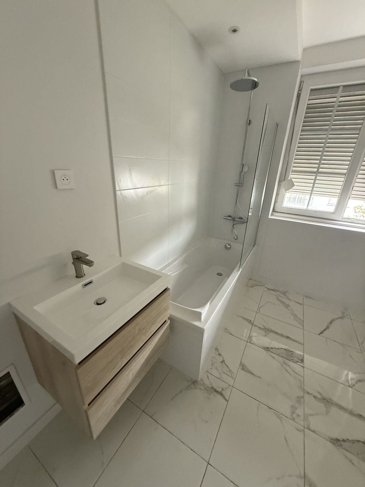 Salle de bain avec baignoire et meuble vasque suspendu