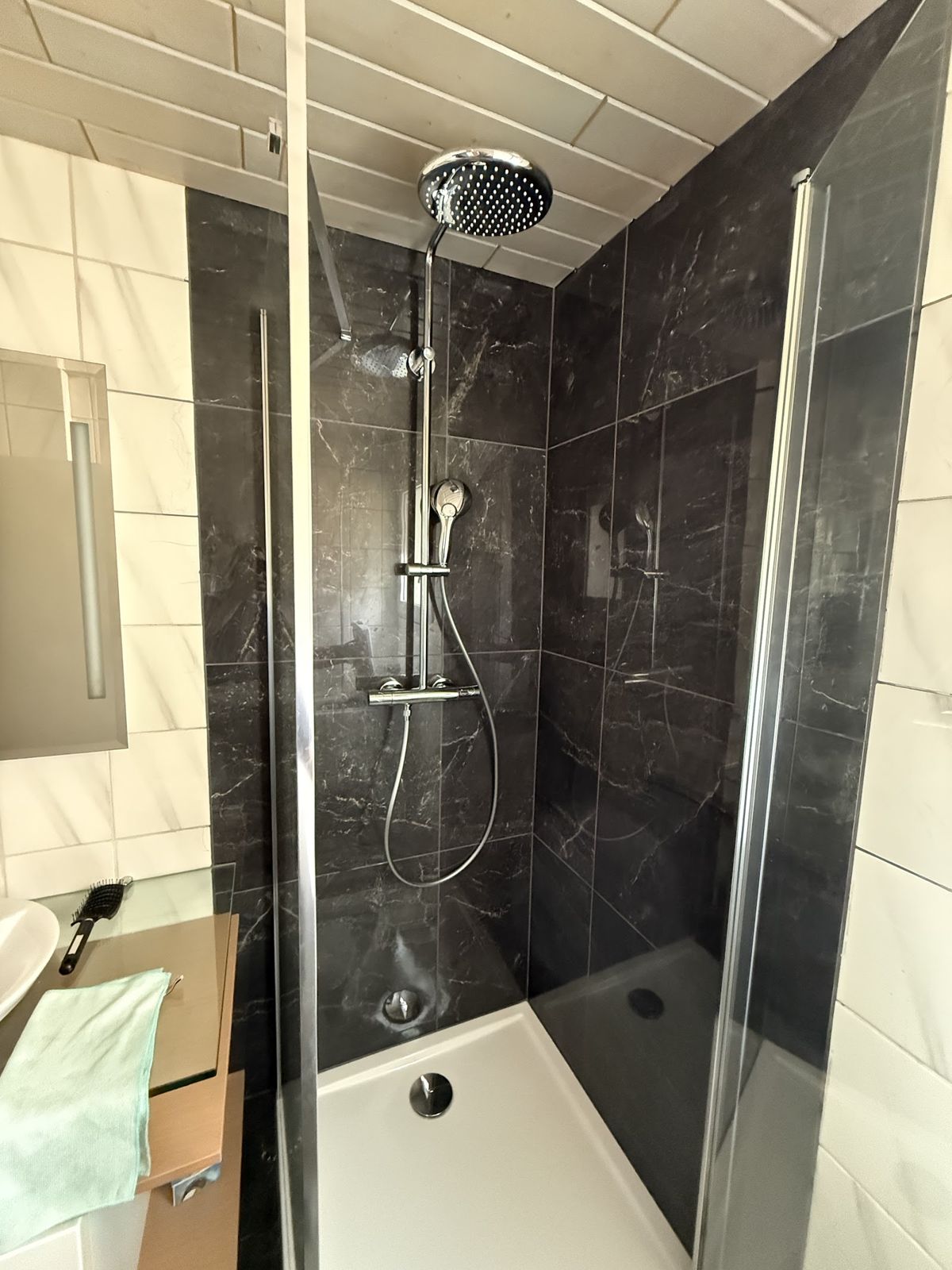 Douche avec paroi vitrée et carrelage noir