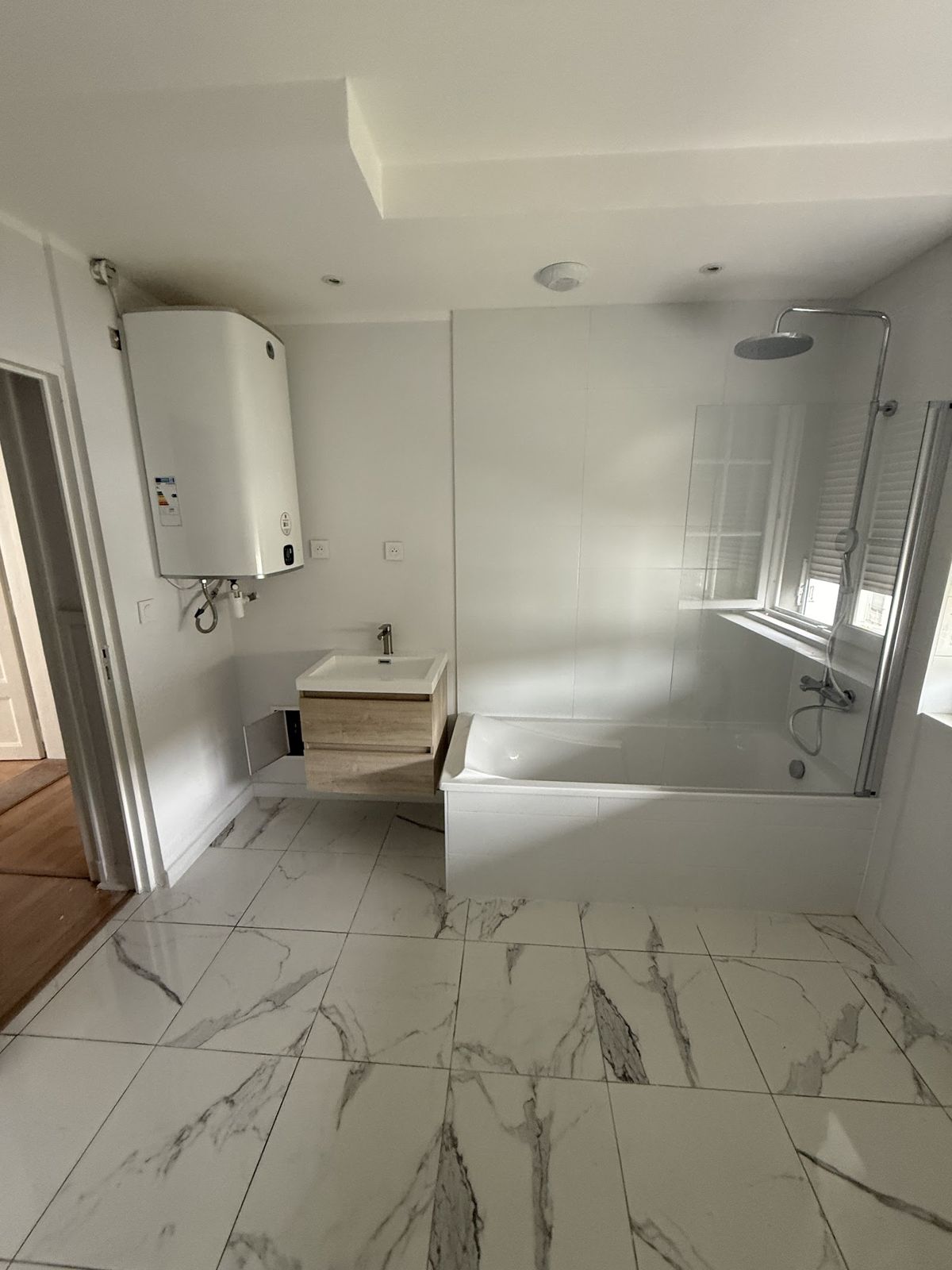 Salle de bain avec baignoire et chauffe-eau mural
